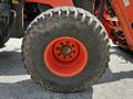 A large agricultural tire with rugged tread and an orange rim, part of a 2011 Kubota M8540D tractor