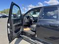 A 2011 RAM 1500 pickup truck with the driver's door open revealing the interior and steering wheel