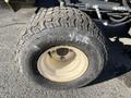 A close-up view of a rear tire from a 2010 Kubota F3990 with a rugged tread design and a white rim showcasing wear and tear