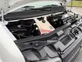 The engine bay of a 2021 Chevrolet Express showing the engine components and a coolant reservoir with visible wiring and connectors
