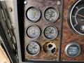 Close-up view of the dashboard of a 1996 Kenworth T800 featuring various gauges for volts water amps and engine RPM along with a quartz hour meter