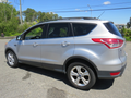 A silver 2015 Ford Escape with a sleek design and five doors featuring alloy wheels and a roof rack