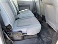 The interior backseat of a 2015 Ford F-450 SD featuring gray cloth upholstery and a simple design with a flat floor and seatbelt mounts