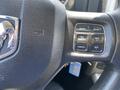 Close-up of the steering wheel controls of a 2015 RAM 1500 featuring buttons for gear selection, cruise control, and on-off functions