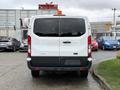A white 2018 Ford Transit van viewed from the rear with a warning light on top and a blank license plate area