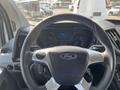 Steering wheel and dashboard of a 2016 Ford Transit showing the Ford logo and various controls