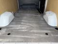 The interior cargo space of a 2021 Mercedes-Benz Sprinter with a gray floor and two wheel wells on the sides