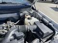 The engine compartment of a 2012 Ford F-150 showing various components including the air intake hose and coolant reservoir