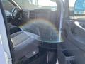 Interior view of a 2012 GMC Savana showcasing the driver's seat dashboard and controls with gray fabric upholstery and a steering wheel