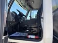 Interior of a 2018 International DuraStar showing the driver's seat steering wheel and dashboard alongside a fire extinguisher and a piece of paper on the floor