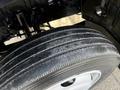 A close-up of a wet tire with visible tread patterns mounted on a 2018 Hino 195 vehicle