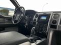 Interior view of a 2014 Ford F-150 showcasing the dashboard steering wheel and center console with controls and gear shift