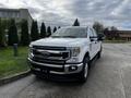 A white 2020 Ford F-250 Super Duty pickup truck parked with a chrome grille and wheels