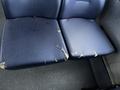 A close-up of two worn and cracked blue vinyl seat cushions from a 2017 Chevrolet Express showing signs of damage and deterioration