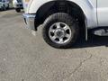 A white 2014 Ford F-350 SD with a shiny alloy wheel and rugged tire in the foreground