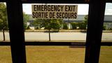 Interior view of a bus showing an emergency exit sign with text in English and French indicating how to operate the exit door