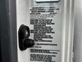 A 2022 Isuzu NPR with a vehicle information label detailing its specifications and tire pressure requirements