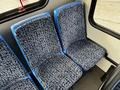 Interior view of two blue and patterned seats in a 2015 Chevrolet Express van