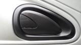 A black door handle for a 2005 International 4300. The handle has a sleek design and is positioned on a textured gray panel.