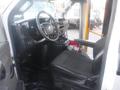 Interior of a 2016 Chevrolet Express showing driver's seat steering wheel and dashboard with controls and cup holders