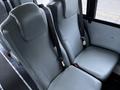 Two gray upholstered bus seats with seat belts attached