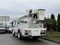 A 2007 International 4200 bucket truck with a white exterior and an elevated arm and bucket for overhead work