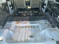 A 2013 Ford Expedition's empty cargo area showing the floor without seats and some visible dirt and rust