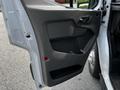 The door panel of a 2022 Ford Transit featuring a gray textured surface with a handle and a speaker mount