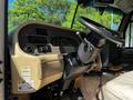 Interior view of a 2000 Ford Motorhome featuring a beige dashboard a steering wheel and various control panels