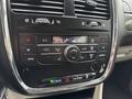 A close-up view of the dashboard controls of a 2017 Dodge Grand Caravan featuring climate control buttons air conditioning and a digital display