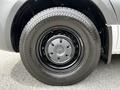 A close-up view of a black tire mounted on a 2023 Mercedes-Benz Sprinter featuring a silver wheel cover with the Mercedes-Benz logo
