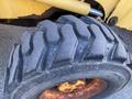 Tread of a large yellow tire on a Komatsu WB156PS-5 backhoe loader with a rugged pattern designed for traction