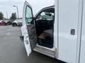 A 2016 Chevrolet Express with an open driver's side door showing the interior including the steering wheel and dashboard