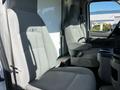 Two gray cloth seats inside a 2019 Ford Econoline with a center console between them