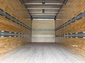 Interior of a 2018 Hino 195 truck showing wooden walls and metal tracking for securing cargo with a wooden floor