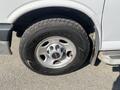 Close-up of a tire on a 2016 GMC Savana featuring a chrome hubcap with the GMC logo and a rugged tread pattern