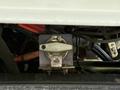 A close-up view of a mechanical component from a 2012 Volvo VNL showcasing a metal switch or valve attached to a base with visible wiring and connections