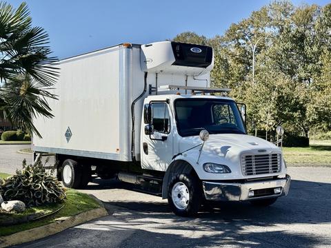 A white 2017 Freightliner M2 106 box truck with a refrigeration unit on top parked on a road