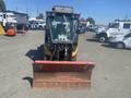 A 2010 Trackless MT6 snowplow with a large metal blade at the front and a cab for the operator