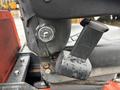 Close-up of the control panel and seat adjustment lever on a 2012 Kubota F3680 tractor with visible water droplets on the surfaces