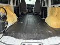 Interior of a 2012 Chevrolet Express van featuring stripped walls and floor with exposed yellow insulation and two front seats