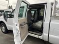 A 2010 Ford F-250 SD with an open passenger door revealing a spacious interior featuring gray seats and a beige door panel