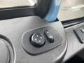 Close-up of a control panel with round buttons featuring directional arrows on a textured surface in a vehicle interior