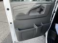 Interior door panel of a 2015 Chevrolet Express featuring a sturdy handle storage compartments and controls for windows and locks