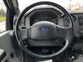 The interior of a 2013 Ford F-650 featuring a steering wheel with the Ford logo and dashboard controls in front of the driver seat