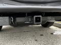 The underside of a 2011 Ford Econoline showing the rear hitch receiver with a black finish and some wiring visible