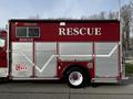 A red 1994 Freightliner FL80 rescue truck with silver paneling and the word RESCUE prominently displayed on the side