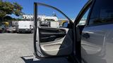 A 2016 Dodge Grand Caravan with its driver's side door open showcasing the interior door panel and controls