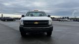 A 2013 Chevrolet Silverado 1500 facing forward with a white exterior and black grille featuring the Chevrolet logo