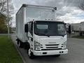 A 2022 Isuzu NPR truck with a box cargo area and a white exterior parked in a lot with clear visibility of its front features